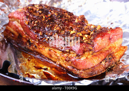 Sliced grilled pork ribs barbecue Striploin steak with chimichurri sauce and tomatoes on cutting board on dark background. Stock Photo
