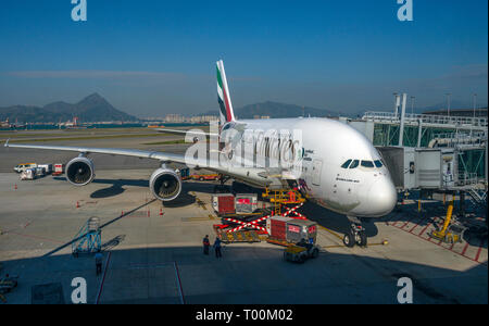 An Emirates Airbus A380-800 airliner viewed from the boarding gate window, Hong Kong Airport. Stock Photo