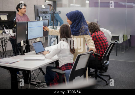 young multiethnics business team of software developers working together using laptop computer while writing programming code at modern startup office Stock Photo