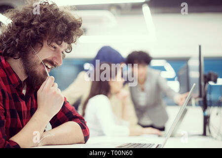 young multiethnics business team of software developers working together using laptop and desktop computer while writing programming code at modern st Stock Photo