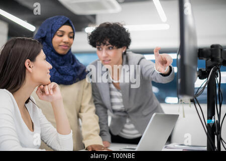 young multiethnics business team of software developers working together using laptop computer while writing programming code at modern startup office Stock Photo
