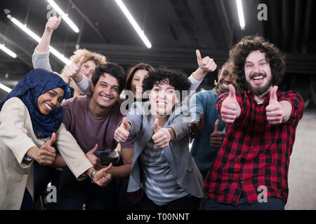 portrait of young excited multiethnics business team of software developers standing and looking at camera while celebrating success at modern startup Stock Photo