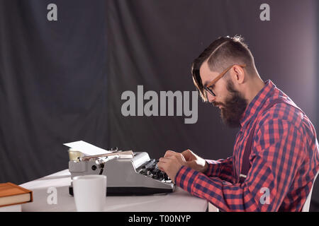 People and technology concept - Portrait of writer working on typewriter Stock Photo
