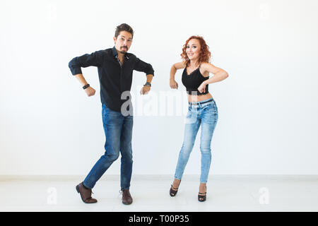 Social dance concept - Crazy dancing, cheerful couple over white background Stock Photo