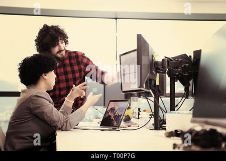 young software developers couple using laptop and desktop computer while writing programming code at modern creative startup office Stock Photo
