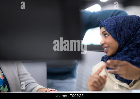 black muslim female software developer working together with her multiethnics business team using computer while writing programming code at modern st Stock Photo
