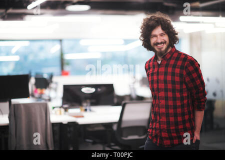 Portrait of young smiling successful male software developer standing at modern startup office Stock Photo