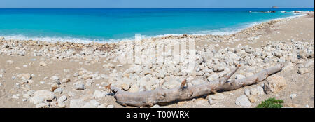 Beautiful summer Lefkada coast panorama with dry trunk of tree on stony beach (Greece, Ionian Sea) Stock Photo