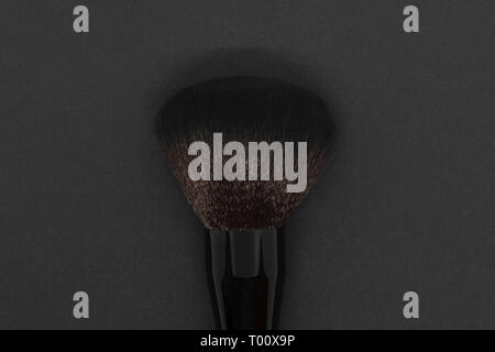 Black makeup with brown shade brush on black background Stock Photo