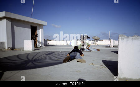 25th October 1993 Members of the media lie low on the roof of the Sahafi Hotel as a fire-fight rages at the K4 roundabout in Mogadishu, Somalia. Stock Photo