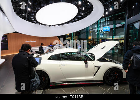 Nissan flagship showroom on the Ginza in Tokyo. Two cars on display, people walking around viewing. Stock Photo