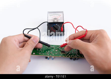 Technician hand with multimeter probes repairing circuit board Stock Photo