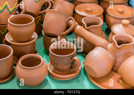 Lots of traditional ukrainian handmade clay pottery production. brown pottery. Clay plates and cups. Stock Photo