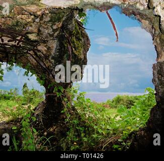 Huge holes from an old Japanese pillbox in San Antonio, near Coral Ocean Point serve as outlet for cannons during the World War 11 in Saipan Stock Photo