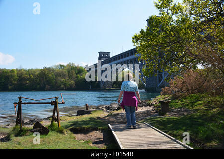 Looking at the mighty Britannia bridge and Menai Strait from the shores of Anglesey. Stock Photo