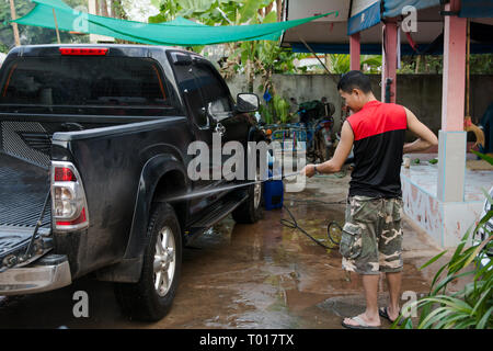 Man washing black pickup truck car with high pressure washer Stock Photo