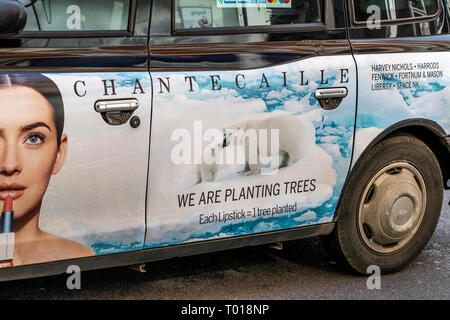 A black cab with advertising for a lipstick brand on the door