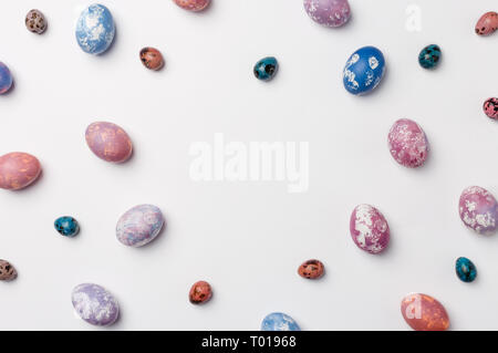 Trendy frame background with quail, pink, purple, orange and blue easter eggs with copy space for text. isolated on white background. Flat lay, top vi Stock Photo