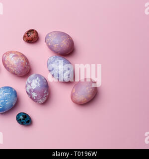 Multicolored eggs and quail eggs on pink background, copy space. Healthy food concept. Top view, flat lay. Easter eggs. Happy Easter concept Stock Photo