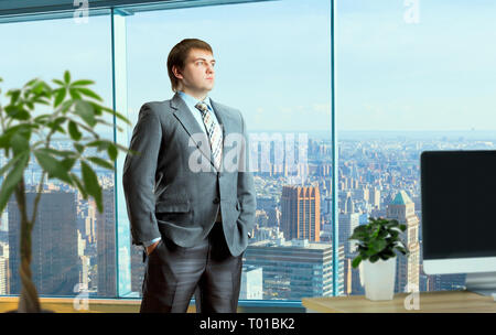 Businessman in suit stands in the middle of office Stock Photo