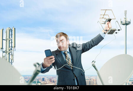 Crazy businessman with antenna and cell phone Stock Photo