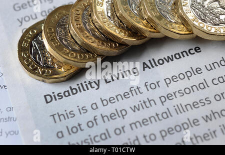 DWP  DISABILITY LIVING ALLOWANCE LEAFLET WITH ONE POUND COINS RE BENEFITS THE ELDERLY PENSIONERS LOW INCOME PENSION CREDIT ETC UK Stock Photo