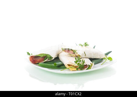 roll of pita with lettuce leaves, greens and sausage in a plate Stock Photo