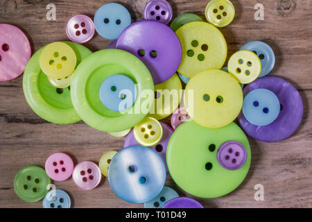 pile of pastel coloured buttons on a wooden background Stock Photo