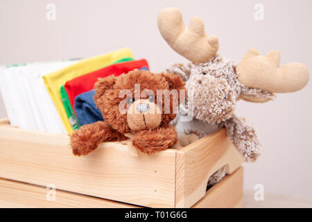Donation concept. Donate box with kids clothes, books, school supplies and toys. TTeddy bear and moose toy Stock Photo