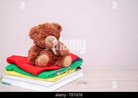 Donation concept. Donate things with kids clothes, books, school supplies and toys. Teddy bear. Copyspace for text Stock Photo
