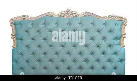 Shaped pastel blue color soft velvet fabric capitone bed headboard of Chesterfield style sofa with carved wooden frame, isolated on white background,  Stock Photo