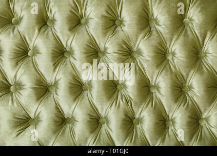 Pastel green velvet capitone textile background, retro Chesterfield style checkered soft tufted fabric furniture diamond pattern decoration with butto Stock Photo