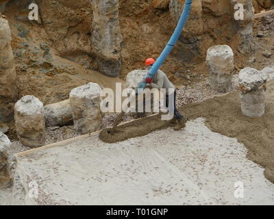 Worker pouring concrete at a construction site Stock Photo