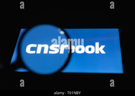 Smartphone lying on a table in the dark, displaying cnsrbook text. The magnifying glass above touch screen. The concept of censorship on popular socia Stock Photo