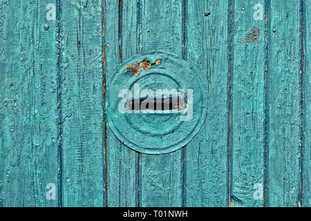 Vintage old boards painted dark turquoise paint with integrated round mailbox Stock Photo