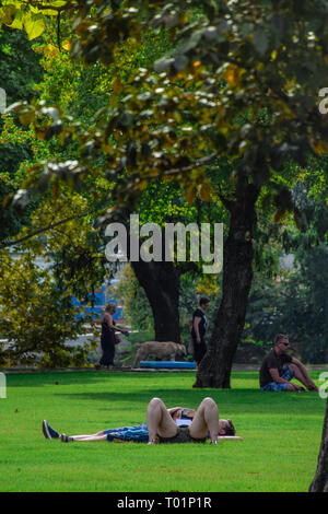 Budapest, Hungary, September , 13, 2019 - People doing activities in V rosliget park ina a sunny day: reading, walking, relaxing, sunbathing Stock Photo