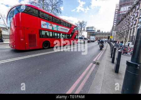 A London bus and a commuter motorcyclist on Victoria Embankment, Westminster, London Stock Photo