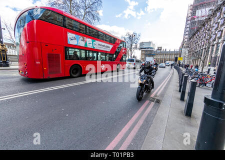A London bus and a commuter motorcyclist on Victoria Embankment, Westminster, London Stock Photo