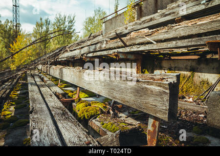 Old football stadium in Chornobyl exclusion zone. Radioactive zone in Pripyat city - abandoned ghost town. Chernobyl history of catastrophe Stock Photo