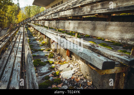 Old football stadium in Chornobyl exclusion zone. Radioactive zone in Pripyat city - abandoned ghost town. Chernobyl history of catastrophe Stock Photo