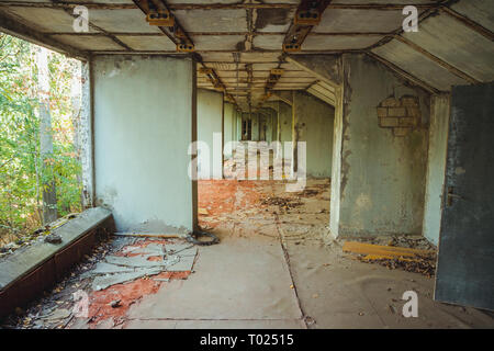 Old football stadium in Chornobyl exclusion zone. Radioactive zone in Pripyat city - abandoned ghost town. Chernobyl history of catastrophe Stock Photo