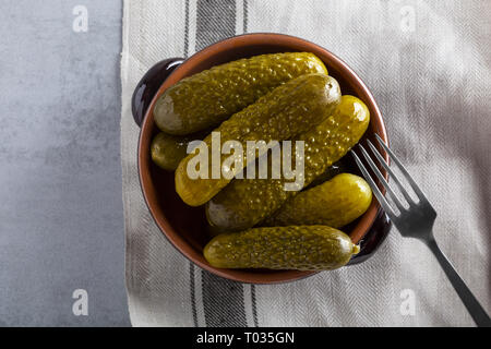 Pickled gherkins with mustard and garlic on a stone rusty background. Stock Photo