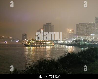 NEW ORLEANS, LOUISIANA—A dinner cruise boat at the Mississippi River heads to dock on a cold foggy night in January 2017. Stock Photo