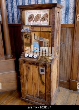 DODGE CITY, KANSAS—SEPTEMBER 2017: Antique wooden penny press machine for penny souvenirs displayed at the Boot Hill Museum. Stock Photo