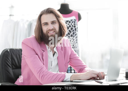 successful designer works on a laptop sitting in his Studio Stock Photo