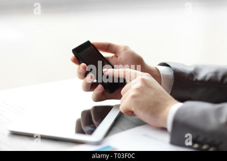 close up.businessman presses his finger on the screen of the smartphone Stock Photo