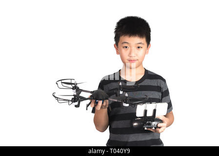 Asian boy holding drone and radio remote control (controlling handset) for helicopter, drone or plane, studio shot isolated on white background with c Stock Photo
