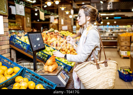 A female customer carries an Apple shopping bag at an Apple retail