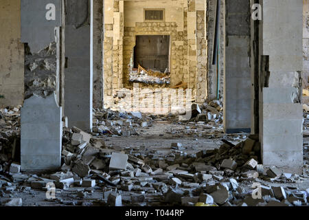 The destroyed internal part of the building in the form of a tunnel of piles with sunlight penetrating in the distance. Stock Photo
