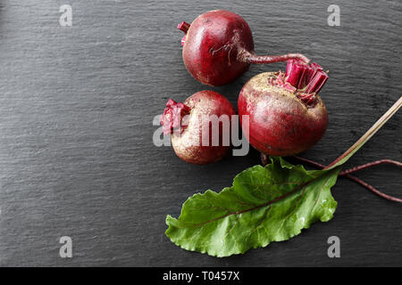 whole young beets on the table, on a black background. space for text Stock Photo